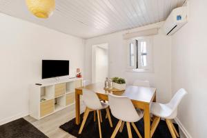 a dining room with a wooden table and white chairs at Prestigegoldresidence 1 - Old Town in Guimarães