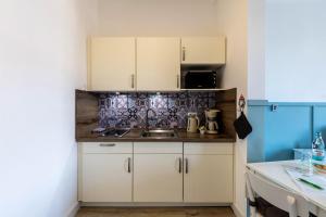 a kitchen with white cabinets and a sink at Schweden Apartment in Kerken