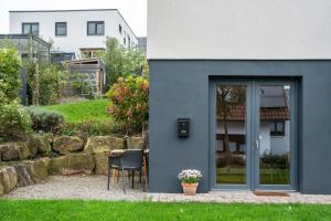a blue house with a table and chairs in a yard at Fewo Kleines Glück in Friesenheim