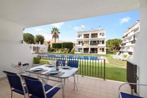 a balcony with a table and chairs and a pool at Mouramar Vilamoura in Vilamoura