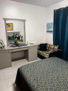 a bedroom with a bed and a mirror and a couch at Mouramar Vilamoura in Vilamoura