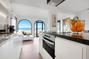 a kitchen with a counter with oranges in a vase at Denia Beach Lodge in Denia +29 photos