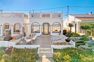 a house with a patio with tables and chairs at Denia Beach Lodge in Denia