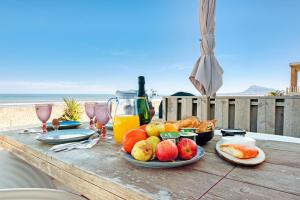 a table with fruit and juice on a table at the beach at Denia Beach Lodge in Denia