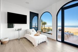 a white room with a bed and a large window at Denia Beach Lodge in Denia