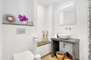 a white bathroom with a sink and a mirror at Denia Beach Lodge in Denia