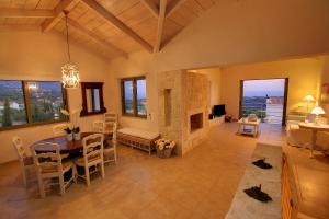 a living room with a table and a fireplace at Villa Linatela Ideales Resort in Kefallonia