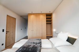 a bedroom with two beds and a wooden door at Valentinerhof Apt Terra in San Michele