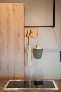 a closet with hangers and a bag on a wall at Valentinerhof Apt Terra in San Michele +36 photos