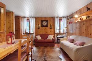 a living room with a couch and a chair at Apartment Corti Garden in Campodolcino