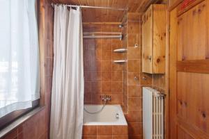 a bathroom with a tub and a shower curtain at Apartment Corti Garden in Campodolcino +18 photos
