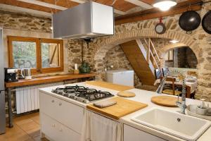 a kitchen with a stove and a counter top at Masia Sa Calma - La Tribu in Susqueda