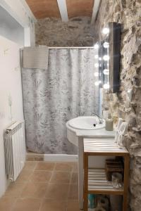 a bathroom with a sink and a shower curtain at Masia Sa Calma - La Tribu in Susqueda +23 photos
