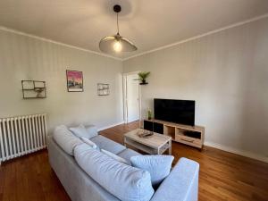 a living room with a couch and a tv at Ty Foch in Lorient
