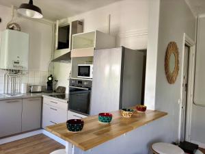 a kitchen with white cabinets and a wooden counter top at Ty Foch in Lorient +10 photos