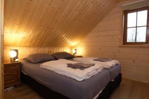 a bedroom with a large bed in a wooden cabin at Houten villa Tine in Den Ham
