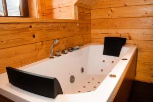 a large bath tub in a wooden bathroom at Houten villa Tine in Den Ham +19 photos