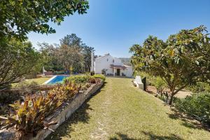 a garden with a swimming pool and a house at Secluded House - Quinta La Rabide in Azeitao