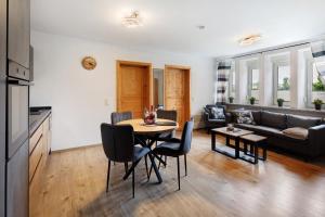 a living room with a table and chairs and a couch at Ferienwohnung Krummel in Edertal +13 photos