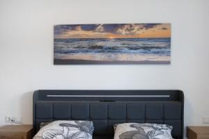 a picture of the ocean on a wall above a bed at Ferienwohnung Krummel in Edertal