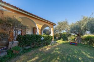 a house with a yard with a bench in the grass at Ciumara East in Avola