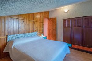 a bedroom with a large bed and wooden walls at Ciumara East in Avola