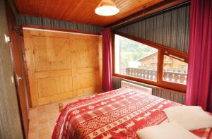 a bedroom with a bed and a window at Le Mont de Grange in La Chapelle-dʼAbondance