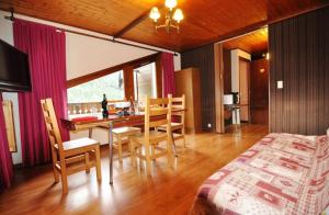 a bedroom with a table and chairs and a bed at Le Mont de Grange in La Chapelle-dʼAbondance