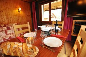 a dining room table with a large loaf of bread on it at Le Mont de Grange in La Chapelle-dʼAbondance