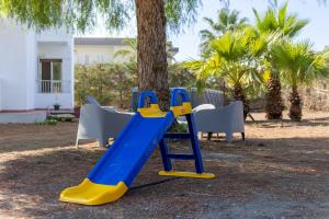 a blue and yellow slide in front of a tree at Villa Tosca dell'Angelo con piscina in Comiso