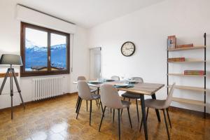 a dining room with a table and chairs and a clock at Palma’s house in Dongo +18 photos