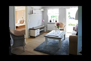 a living room with a coffee table and a couch at Ferienhaus Nanny Und Helene in Uphusum