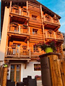 a wooden building with balconies and flowers on it at Chalet du Paradis in Cogne