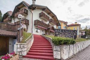 a building with a red staircase in front of it at Giongo Residence Aparthotel 101 in Lavarone