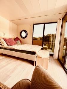 ein Schlafzimmer mit einem Bett und einem großen Fenster in der Unterkunft Hausboot Eisvogel in Kirchberg an der Raab
