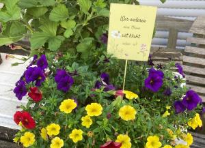 a pot of flowers with a sign in it at Ferienwohnungen Hubertus in Metzingen