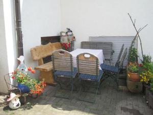 a patio with a table and chairs and flowers at Ferienwohnungen Hubertus in Metzingen