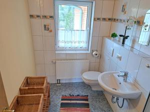 a bathroom with a sink and a toilet and a window at Ferienwohnung Sonnenschein in Nagel +24 photos