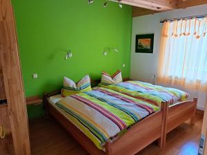 a bedroom with a bed with a green wall at Ferienwohnung Sonnenschein in Nagel