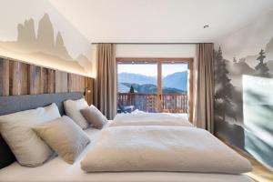 a bedroom with two beds and a large window at Lechnerhof - Clara´s Mountain Lodge in Rodengo