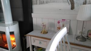 a room with a fireplace and a table with a chair at Gîte Shabby Blue in Saint-Cernin