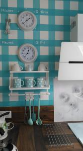 a room with clocks and utensils on a wall at Gîte Shabby Blue in Saint-Cernin