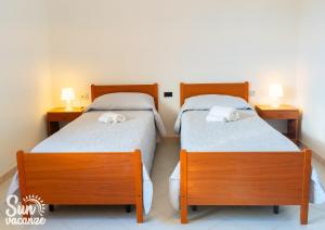 two beds in a small room with two lamps on tables at Villa Malamuri in Budoni +30 photos