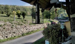 a bird cage hanging from a wall next to a road at Gîte Shabby Blue in Saint-Cernin