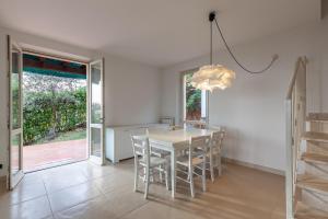a dining room with a white table and chairs at Villa Martina in Pietrasanta