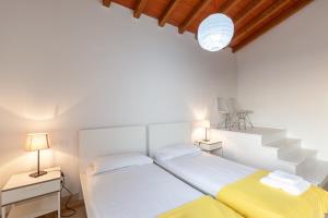a white bedroom with two beds and stairs at Villa Martina in Pietrasanta +24 photos