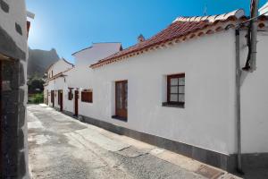 an alley with white buildings and a mountain in the background at Casa De La Eterna Primavera in San Bartolomé