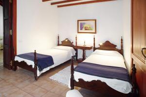 a bedroom with two beds and a table in it at Casa De La Eterna Primavera in San Bartolomé
