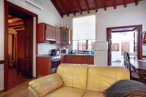 a living room with a yellow couch in a kitchen at Casa De La Eterna Primavera in San Bartolomé