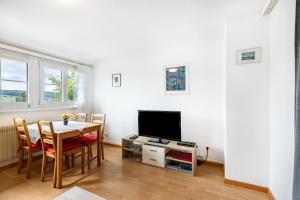 a living room with a table and a television at Gita in Öhningen